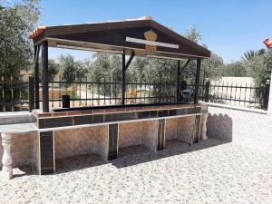 a pavilion with a bench in a park at شاليهات ومسابح مزارع in Al Azraq ash Shamālī