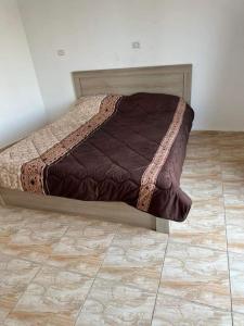 a bed sitting in a bedroom with a tiled floor at شاليهات ومسابح مزارع in Al Azraq ash Shamālī