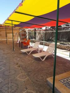 a group of chairs under a tent on a patio at شاليهات ومسابح مزارع in Al Azraq ash Shamālī