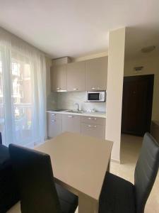 a kitchen with a table and chairs and a microwave at Irina Apartments in Ravda +11 photos