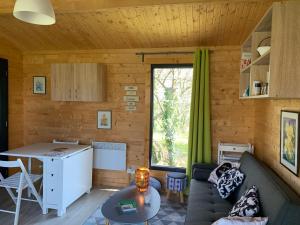 una sala de estar con un sofá y una mesa en Eco-lodge Ecoute la Vie, en Lunay