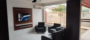 uma sala de espera com cadeiras e uma TV de tela plana em Hotel Sta Mônica Marília em Marília mais 45 fotografias
