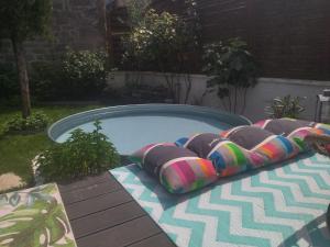 a swimming pool with four pillows in a backyard at Le Pressoir chambres d'hôtes in Cardaillac