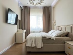 a white bedroom with a bed and a window at Family Suite for 4 - 6 people! Direct access to Tashkent CITY MALL, Central Park, Hilton Hotel, Chorsu Bazaar! in Tashkent +25 photos