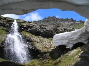 a waterfall on the side of a mountain next to a waterfall at TODOSIERRANEVADA ZONA BAJA - MONTBLANC VISTAS A LA MONTANA - Junto a los Telecabinas in Sierra Nevada