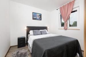 un dormitorio con una cama y una ventana en Apartment Mara by EL-PI TOURS, en Malinska 28 fotos más