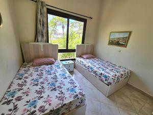 two beds in a room with a window at Twinhouse for rent in Marassi in El Alamein