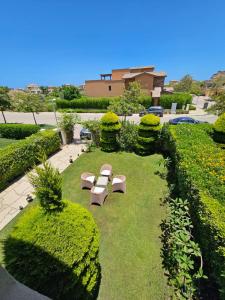 a park with benches and bushes and a building at Twinhouse for rent in Marassi in El Alamein