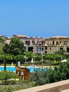 a resort with a swimming pool with umbrellas at Twinhouse for rent in Marassi in El Alamein