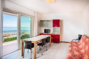 a dining room with a table and a view of the ocean at Appartamenti BIANCO NERO in Lignano Sabbiadoro