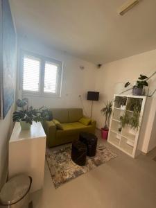 a living room with a green couch and some plants at Dela in Hvar