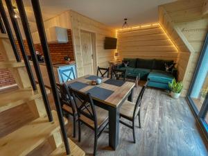 a dining room and living room with a table and chairs at Apartamenty z widokiem na Tatry- Gawronie Gniazdo, Ząb in Ząb