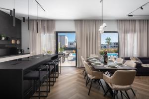 una cucina e una sala da pranzo con tavolo e sedie di Villa M a Vodice