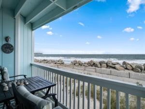 a balcony with a view of the beach and the ocean at Beach Bliss condo in Carolina Beach