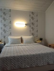 ein Schlafzimmer mit einem großen Bett mit einer weißen Tagesdecke in der Unterkunft Nikolas House in Asprovalta