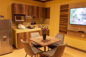 a kitchen with a table and chairs with a vase of flowers at FORTICH APART HOTEL in Guayaquil