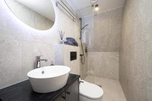 a bathroom with a white sink and a toilet at Pärnu Pearl Residences in Pärnu +56 photos