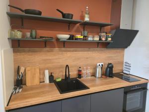 a kitchen counter with a sink and utensils at The Atelier in Burgas City