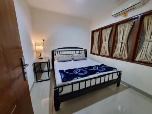 a bedroom with a bed in a room with windows at Awana AT 43 Near Malioboro in Timuran