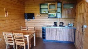 a kitchen and dining room with a table and a counter at Wantaris - domki letniskowe z ogródkiem Mielno-Mielenko in Mielno