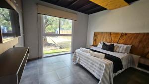 a bedroom with a large bed and a large window at OlivaNegra Resort - Oliva2 in Maipú
