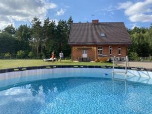 a large swimming pool in front of a house at Siedlisko Jesionna in Rakowiec