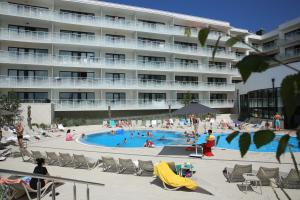 a group of people in a swimming pool in front of a building at Apartament Lux Tukan B005 Polanki Aqua - Holiday City in Kołobrzeg