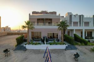 a building with palm trees in front of it at Sea Villa Chalets in An Nāmī