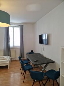 a living room with a table and blue chairs at City Apart Hannover in Hannover