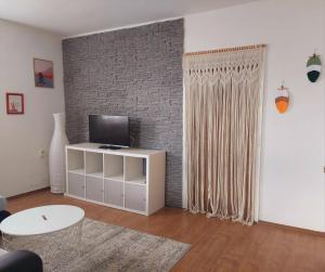 a living room with a television and a brick wall at Ferienwohnung Leonhardbauer in Kleinfeistritz