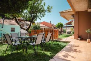 a patio with a table and chairs in the grass at Greg's House in Vitalades