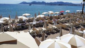 un grupo de sillas y sombrillas en una playa en Hotel le Romanesque en Cannes