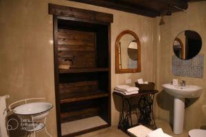 a bathroom with a sink and a toilet and mirror at Agriturismo Volpignano in Collesano