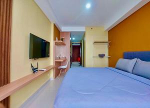 a bedroom with a large bed and a television at Serene Studio Pollux Batam Center - High Floor Sea View in Batam Center