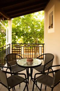 a table and chairs on a balcony with a cake on it at Ostrica Family House in Lefkímmi
