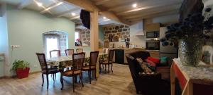 a kitchen and living room with a table and chairs at Le Mazel in Saint-Agrève