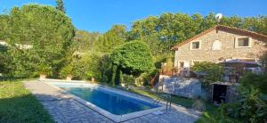 a swimming pool in a yard next to a house at l'Oulibo in Villeneuve-les-Corbières