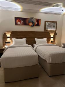 two beds in a hotel room with two beds sidx sidx sidx at Best Trip Marsilia Served Apartments in Jeddah +21 photos