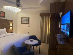 a hotel room with a bed and a tv at Best Trip Marsilia Served Apartments in Jeddah