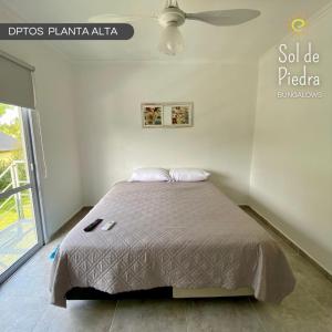 a bedroom with a bed and a ceiling fan at Bungalows Sol de Piedra in Federación +11 photos