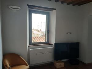a living room with a tv and a window at Tuscany boutique apartment in Manciano
