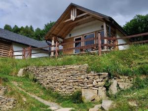een huis met een stenen muur ervoor bij Podbucznik 3 Leskowiec in Targoszów
