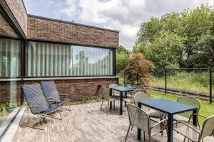 a patio with tables and chairs and a brick building at Gare 55 in Evergem