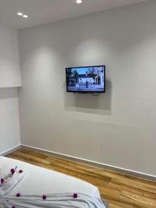 a tv on a white wall in a room at Relax Stay in Ksamil