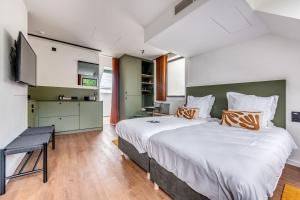 a bedroom with a large bed and a kitchen at Gare 55 in Evergem