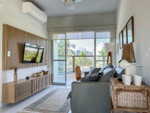 a living room with a couch and a tv at Maravilhosa Vista Mar c/Enxoval completo - Riviera in Riviera de São Lourenço