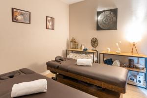 a massage room with a bed and a table at La Closerie SPA & Résidence Hôtel in Deauville