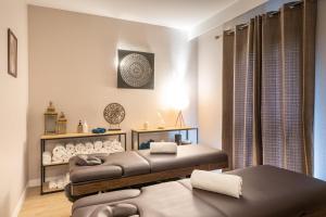 a living room with two beds in a room at La Closerie SPA & Résidence Hôtel in Deauville