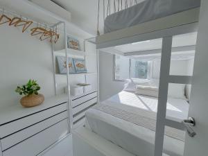 a white bedroom with a bunk bed and a window at Maravilhosa Vista Mar c/Enxoval completo - Riviera in Riviera de São Lourenço +31 photos