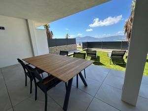 a wooden table and chairs on the balcony of a house at Résidence du Château d'eau in Porticcio